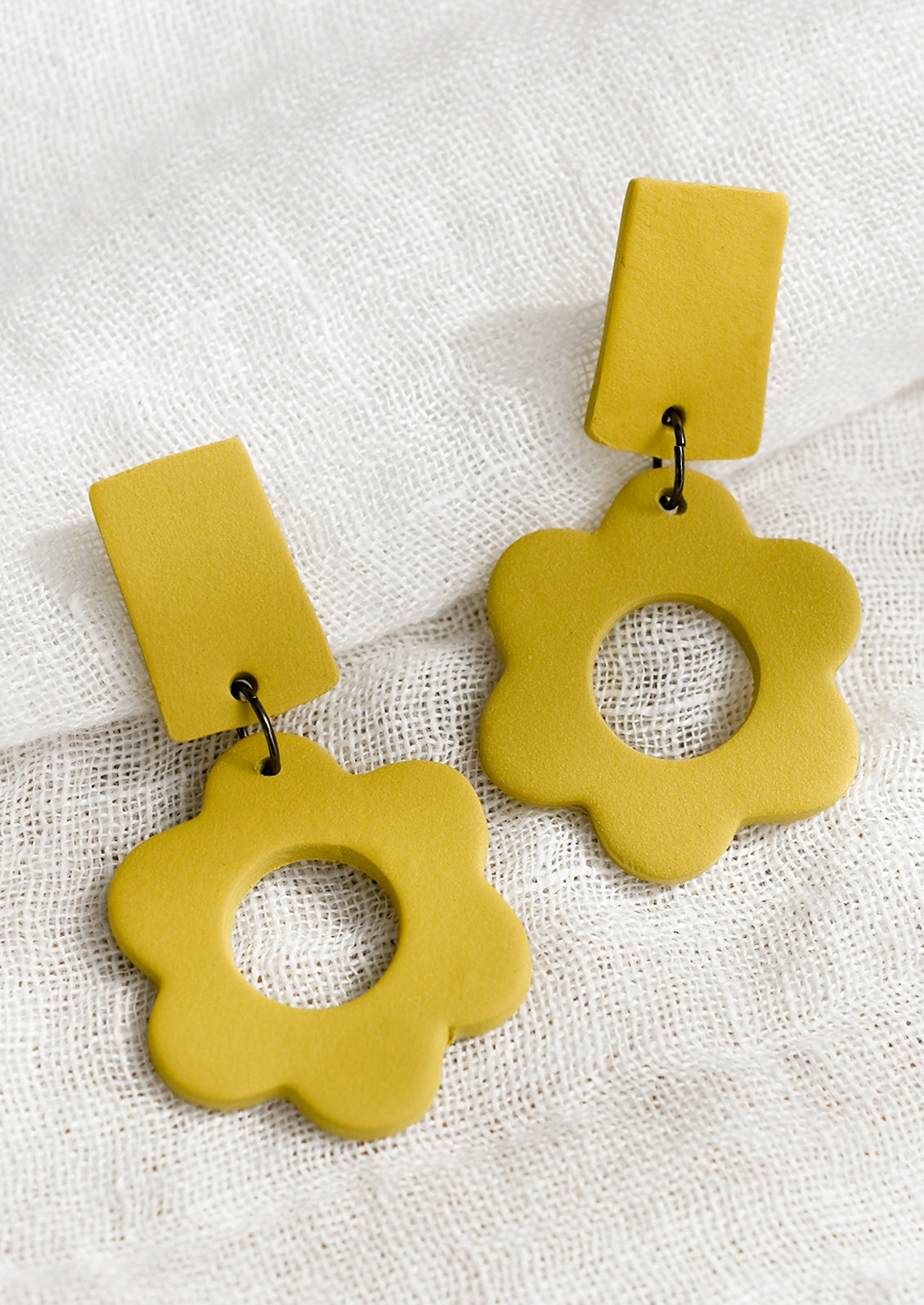 A pair of clay flower earrings with bar-shape post back in lemon rind yellow..