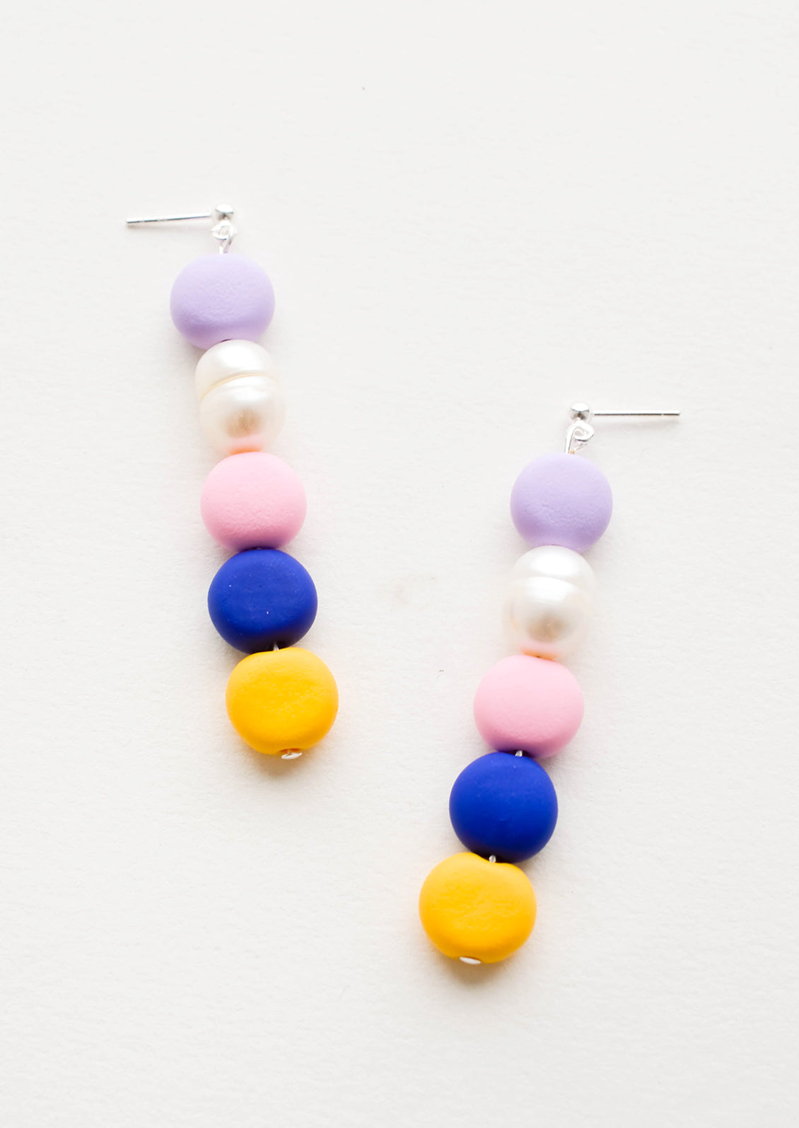 Earrings with colorful clay beads stacked in a row mixed with one pearl bead